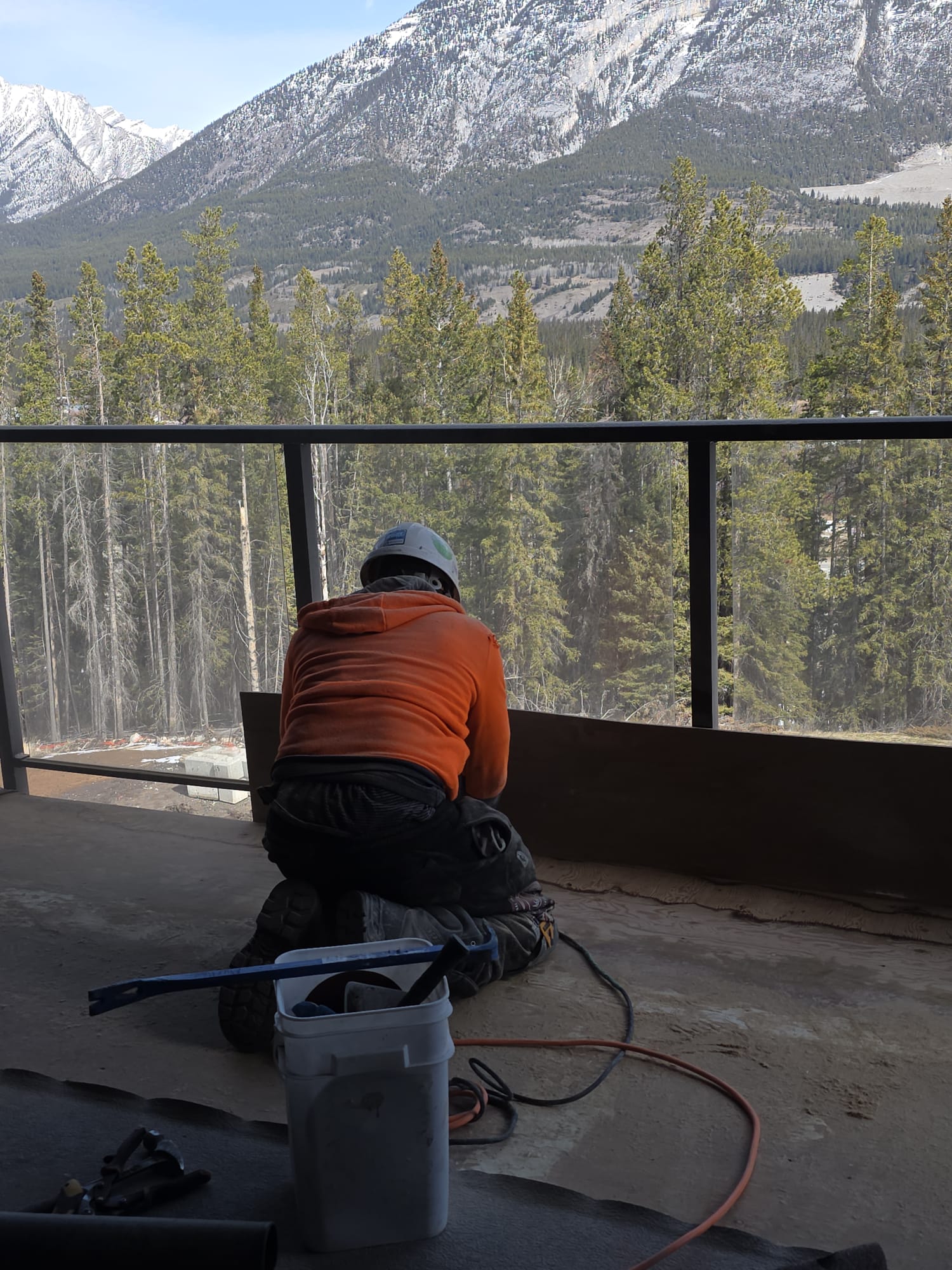 OBYS-OVIE crew member working on a railing installation with a mountain backdrop